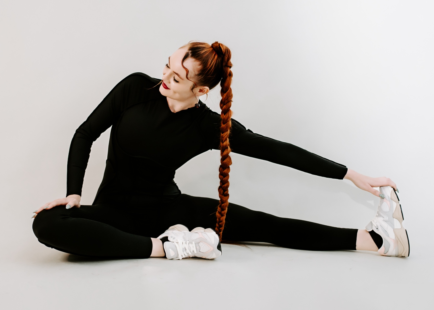 Coach Jamie stretching on floor in a splits position